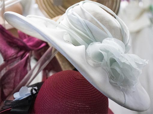 Dettagli che fanno la differenza. Cappello bianco in raso con un fiore che lo avvolge per un tocco chic. Collezione Inclusive.