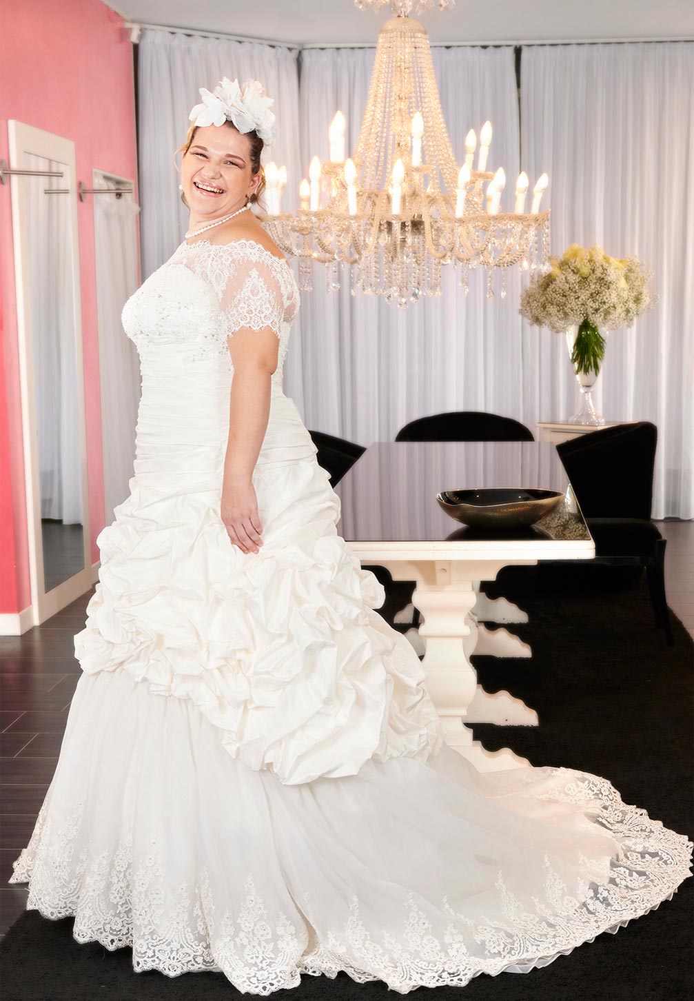 Abito da sposa curvy intero in taffetà di seta dai colori caldi leggermente più dorati dell’avorio, dal maxi volume con scenografici drappeggi che valorizzano fino in fondo la gonna in pizzo ricamato. 