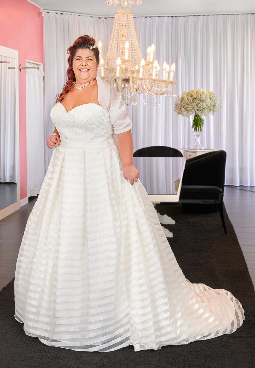 Abito da sposa curvy. Abito intero in tessuto di raso a righe dalla tramatura in avorio con bustiere in pizzo macramè, chiusura bottoni e ampia gonna.